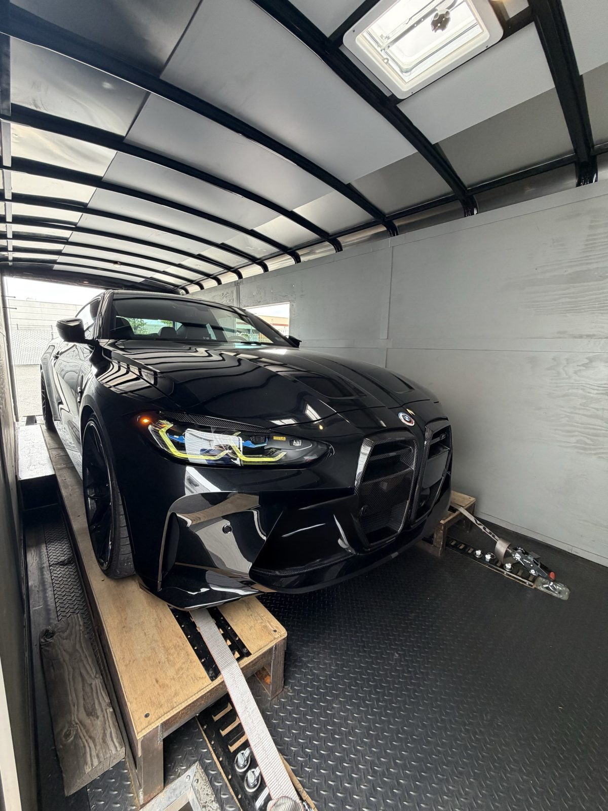 Black BMW M4 inside the enclosed trailer