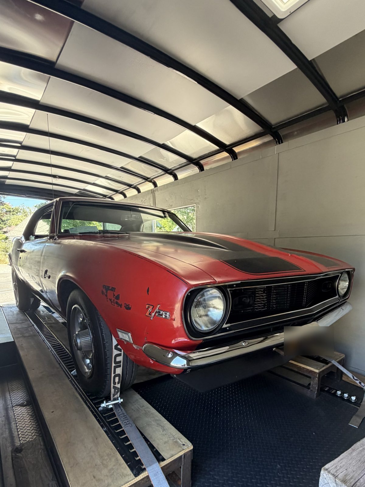 Red Camaro Z/28 with original patina loaded for transport