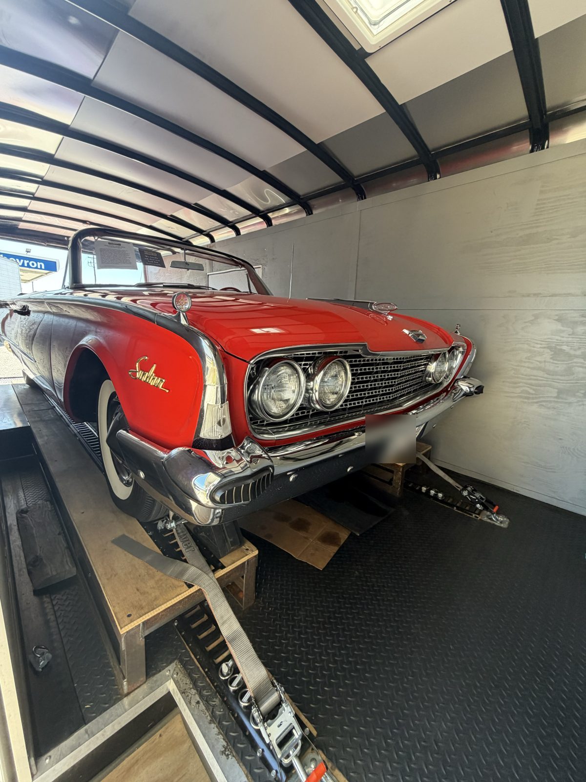 Red 1960 Ford Sunliner convertible loaded for transport