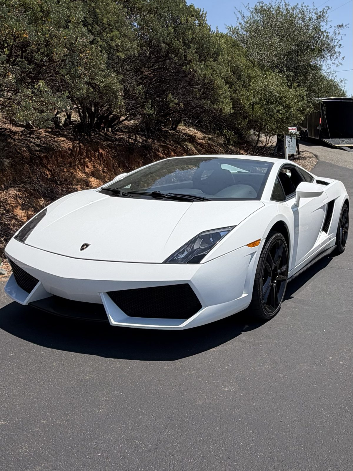 White Lamborghini Gallardo ready to load, trailer in the background
