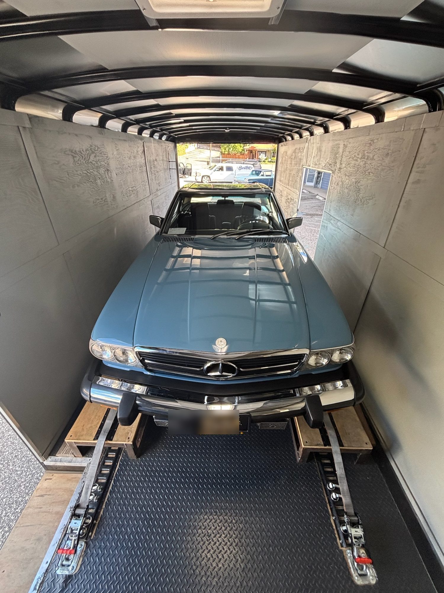 Blue Mercedes SL secured in the enclosed trailer